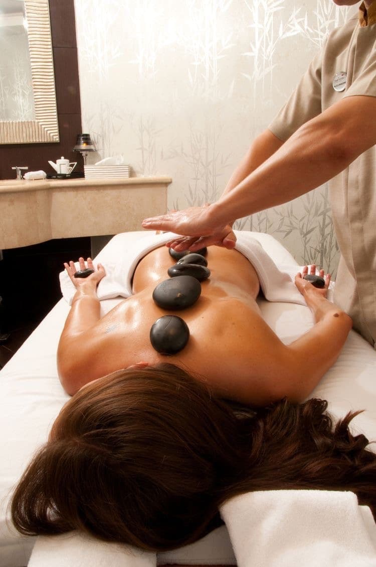 Massagem relaxante com pedras quentes em ambiente de spa